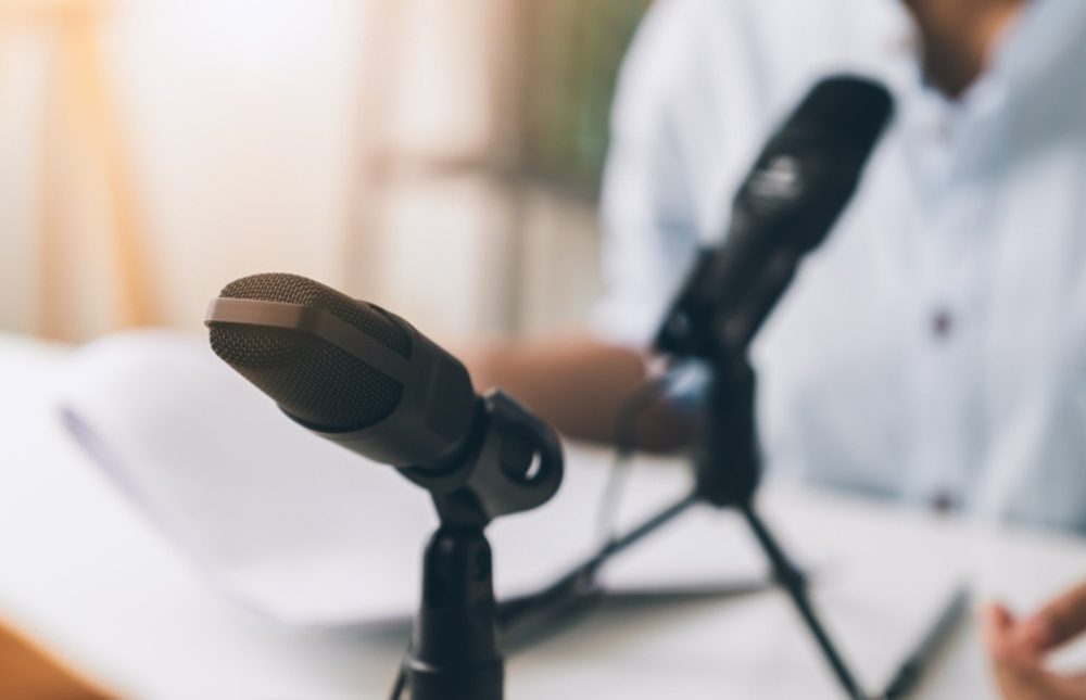 Two microphones are set up on a desk for an interview.