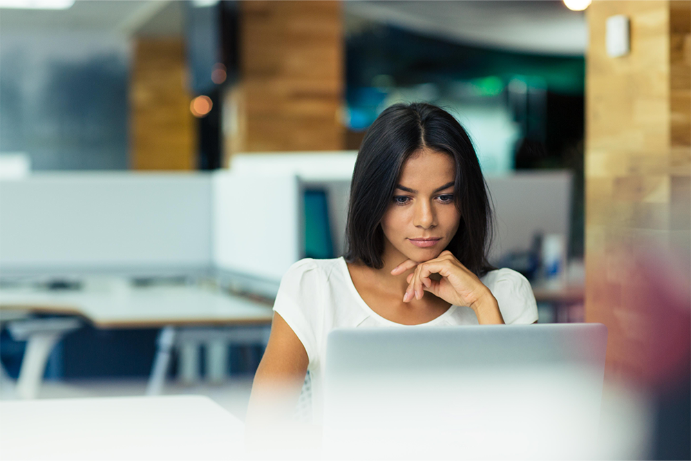 Young woman working at a laptop in a modern office