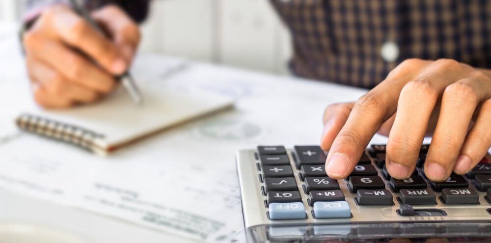 Businessman,Hand,Using,Calculator,Calculating,Bonus(or,Other,Compensation),To,Employees