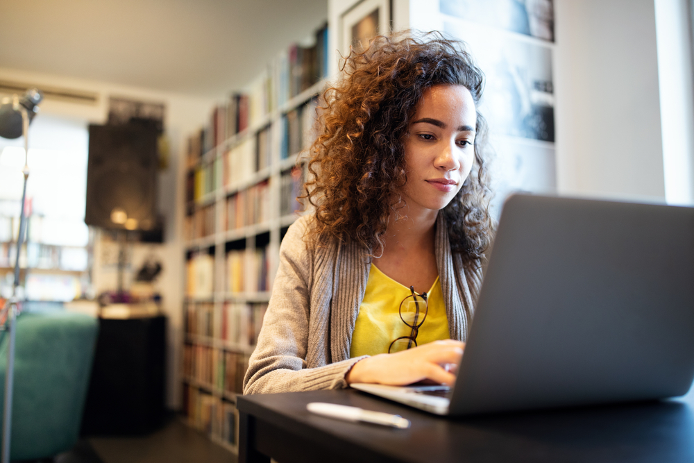 Young girl sitting at her laptop, working.